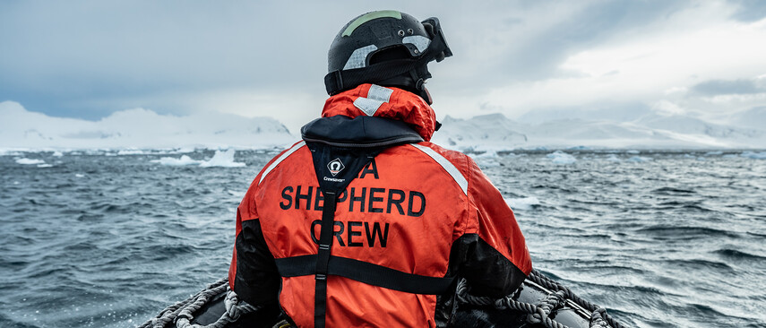 Ein Mann mit roter Sea Shepherd Crew Jacke auf einem Boot auf dem Meer