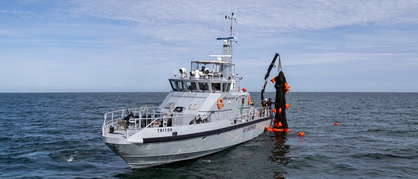 Ein Mann mit roter Sea Shepherd Crew Jacke auf einem Boot auf dem Meer